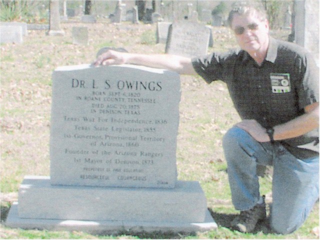 Mr. B. C. Thomas kneeling beside the monument of Dr. L. S. Owings at Denison.