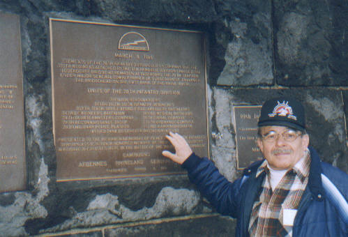 Wolfgang Nitsch, a German friend of the 78th Division veterans, pointing to the huge bronze plaque at Remagen, honoring the role of the U. S. 78th Division in fighting in the Remagen Bridgehead.